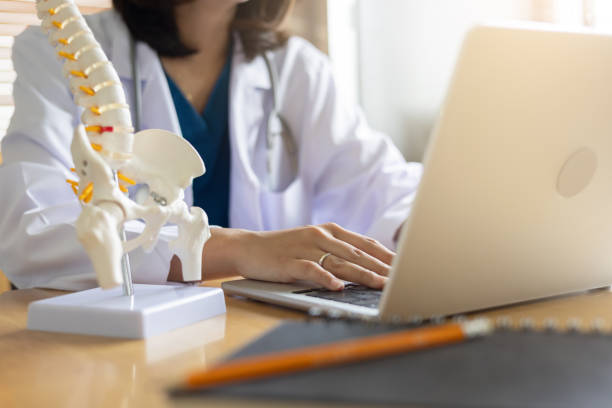 femme médecin devant un ordinateur avec un squelette en premier plan